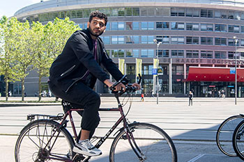 Male student on bike riding through campus