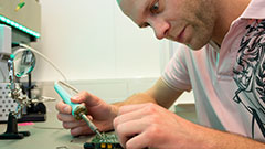 Male student using a soldering iron