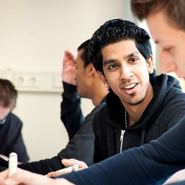 Male student discussing lesson with classmate