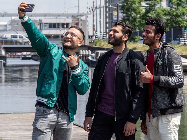 Three male students smiling and taking a selfie